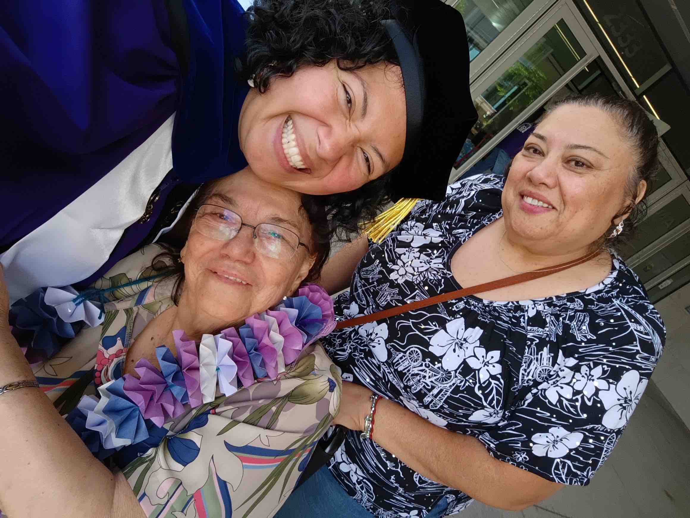 Group selfie of V in their cap and gown with their mom and grandma.